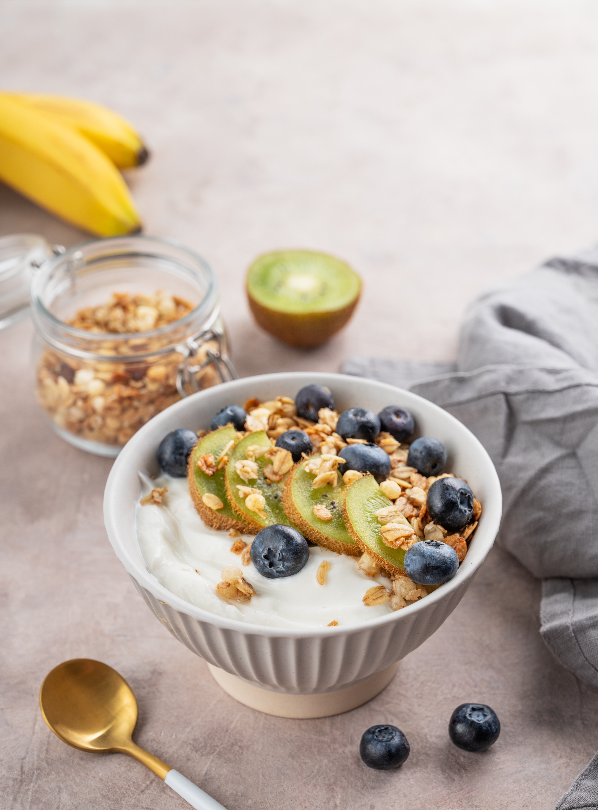 Eine Kiwi-Blaubeer-Bowl mit Joghurt, Granola und Nüssen, angerichtet in einer Schale als gesundes Frühstück.