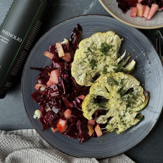 Vegetarische gebackene Blumenkohlsteaks in der Kräuterkruste mit Rotkohlsalat